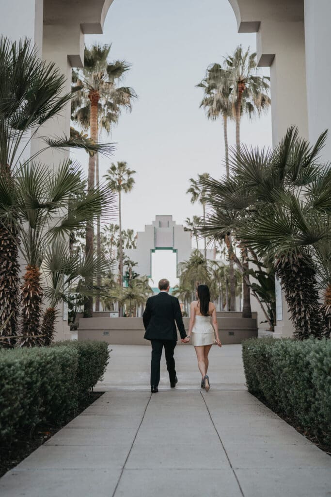 Couple walking toward Beverly Hills City Hall at the start of the architectural portion of their engagement session