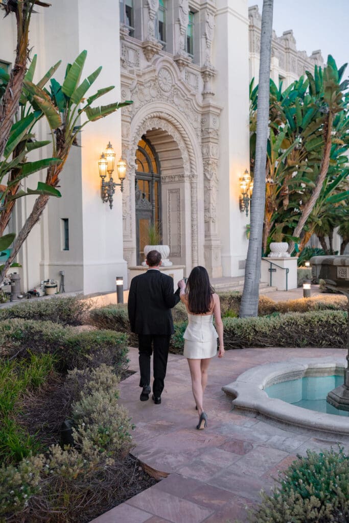 Couple posing at Beverly Hills City Hall during blue hour with the building's warm exterior lights glowing