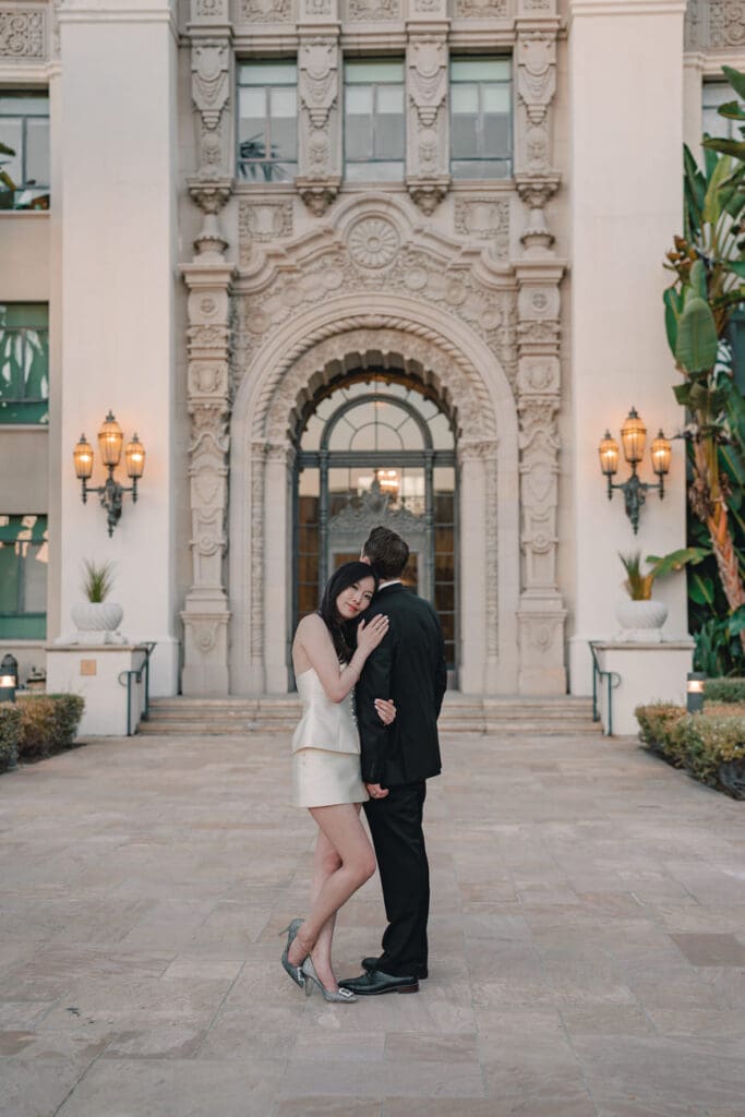 Couple sitting on the steps near columns at Beverly Hills City Hall during a formal engagement photo session