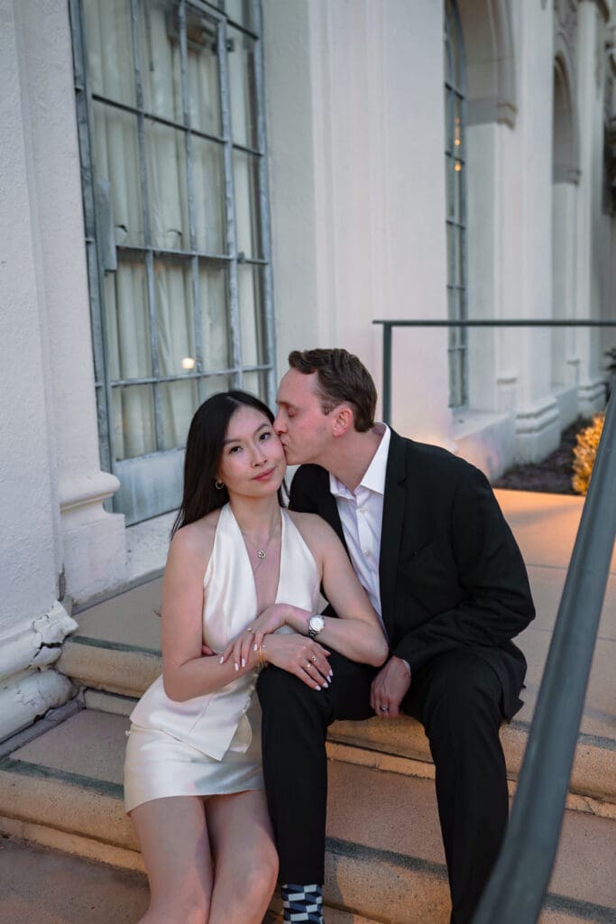 Flash portrait of couple in front of Beverly Hills City Hall at blue hour with warm building lights in the background