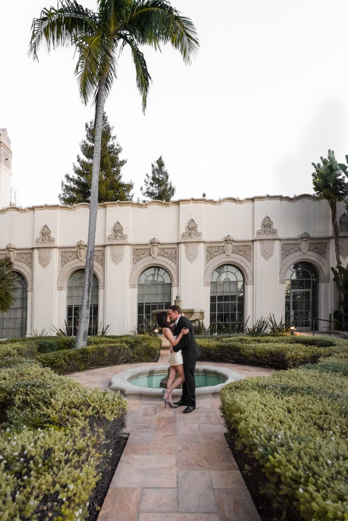 Formal portrait of couple in coordinated outfits in front of Beverly Hills City Hall architecture