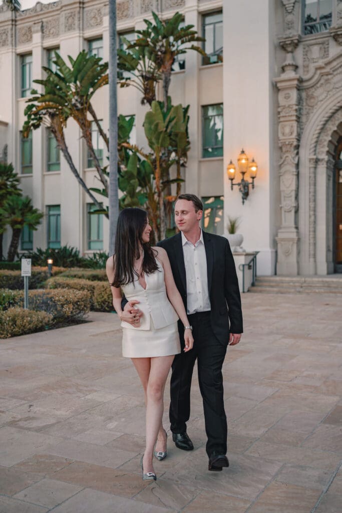 Couple posing against carved stone architectural details at Beverly Hills City Hall during engagement photos