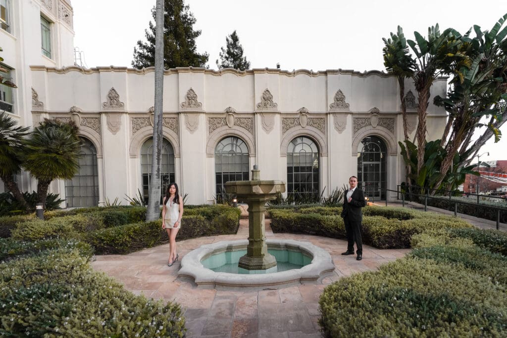 Candid moment of couple walking through the Beverly Hills City Hall grounds during engagement photos