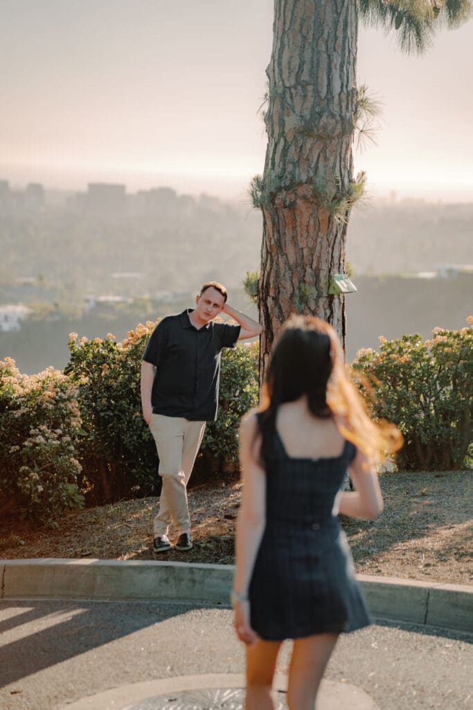 Couple embracing with panoramic city views behind them during Beverly Hills engagement photos in Trousdale Estates