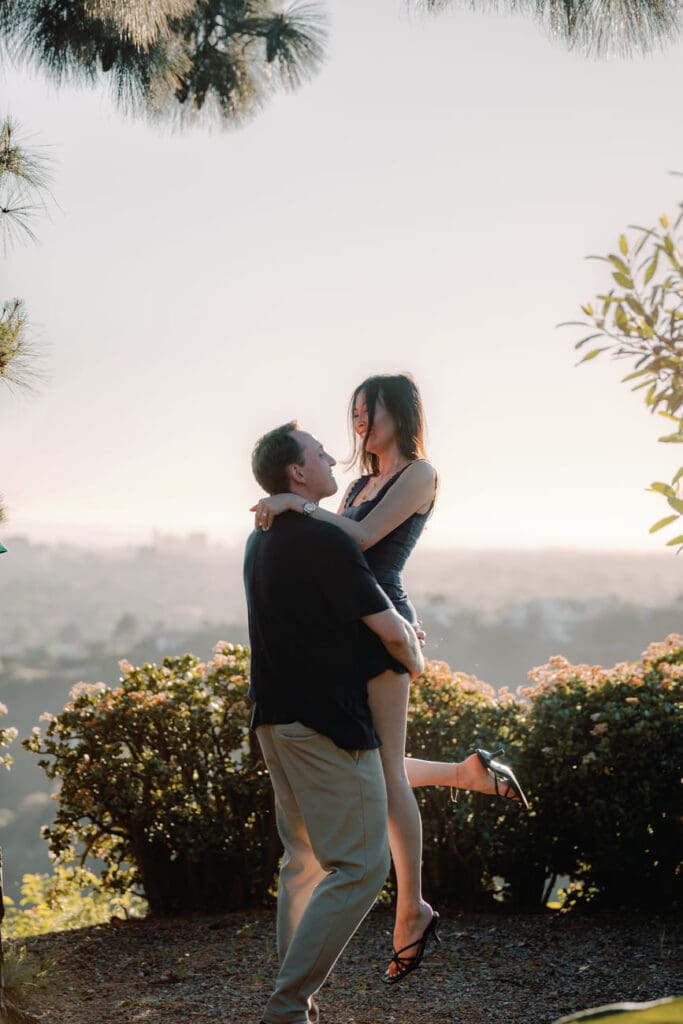 Couple kissing at golden hour on a Trousdale Estates hillside during Beverly Hills engagement photos