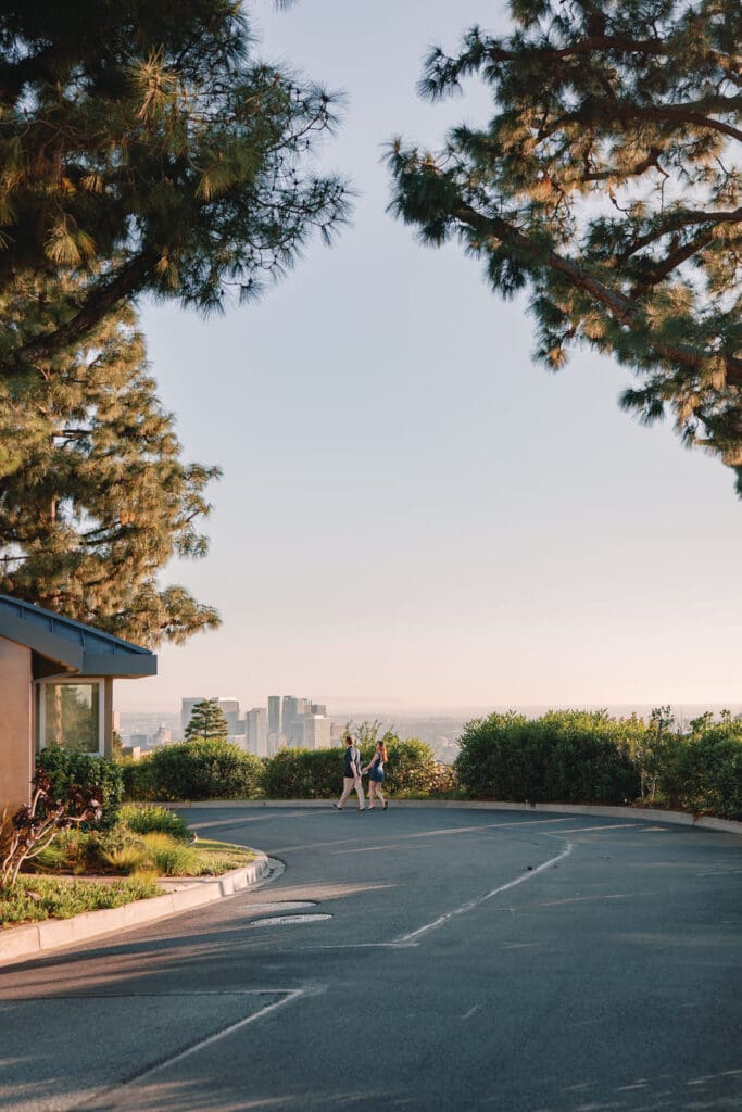 Couple embracing at a quiet overlook in the Trousdale Estates hills with LA views during Beverly Hills engagement photos