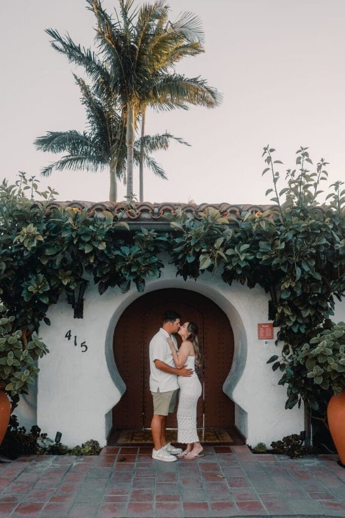 Couple posing together under the arched entryway at Casa Romantica in San Clemente, California.