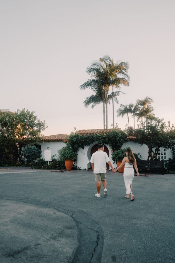 Couple walking toward Casa Romantica before their engagement photos in San Clemente, California.