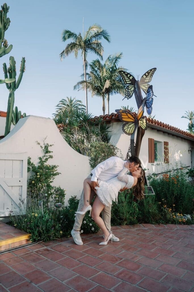 Couple sharing a playful dip in the main garden courtyard for Casa Romantica engagement photos in San Clemente, California.