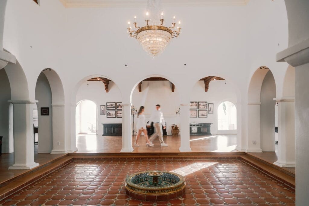 Motion blur of couple walking across the arches inside Casa Romantica.
