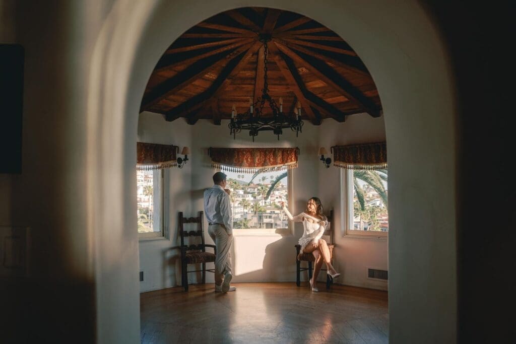 Couple framed by an arched doorway inside the museum rooms at Casa Romantica in San Clemente, California.