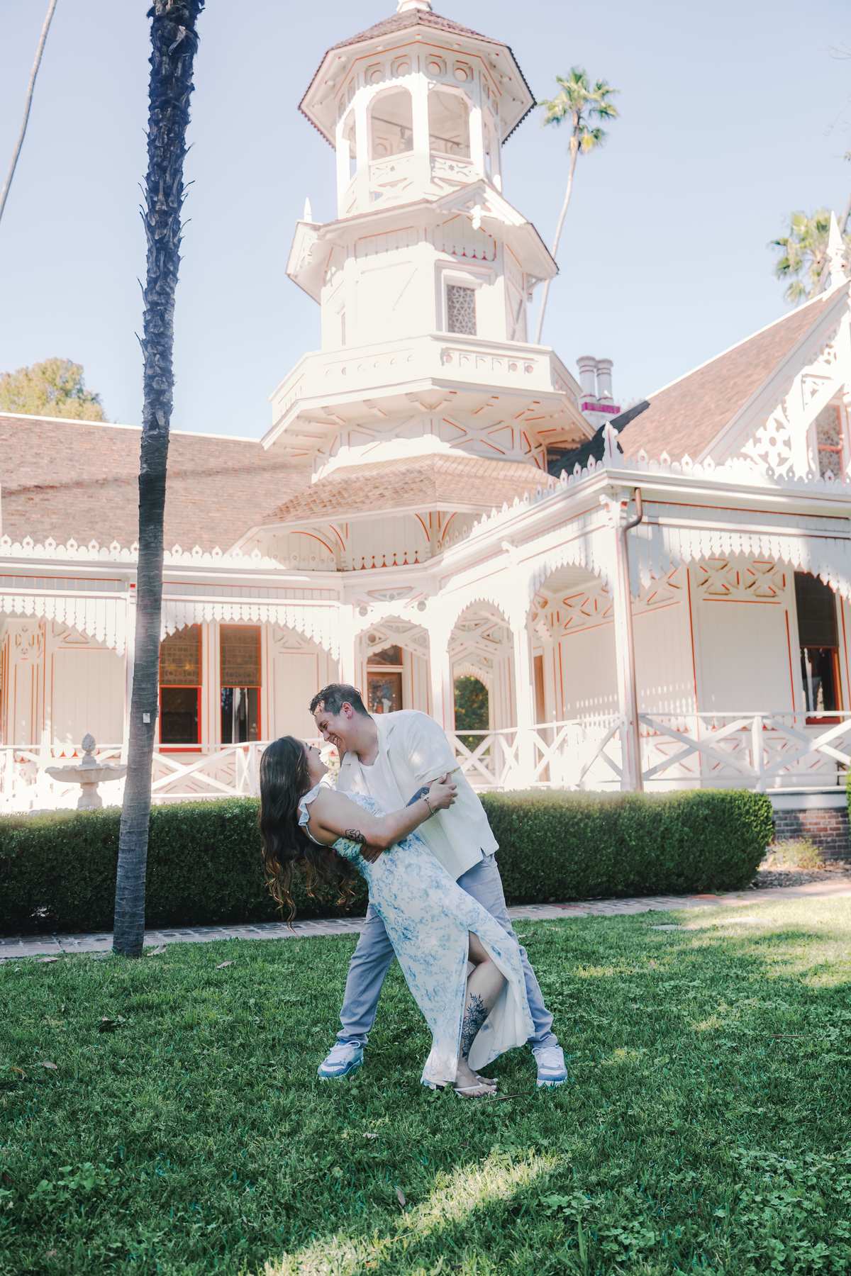 Couple posing on the lawn in front of historic Queen Anne Cottage.