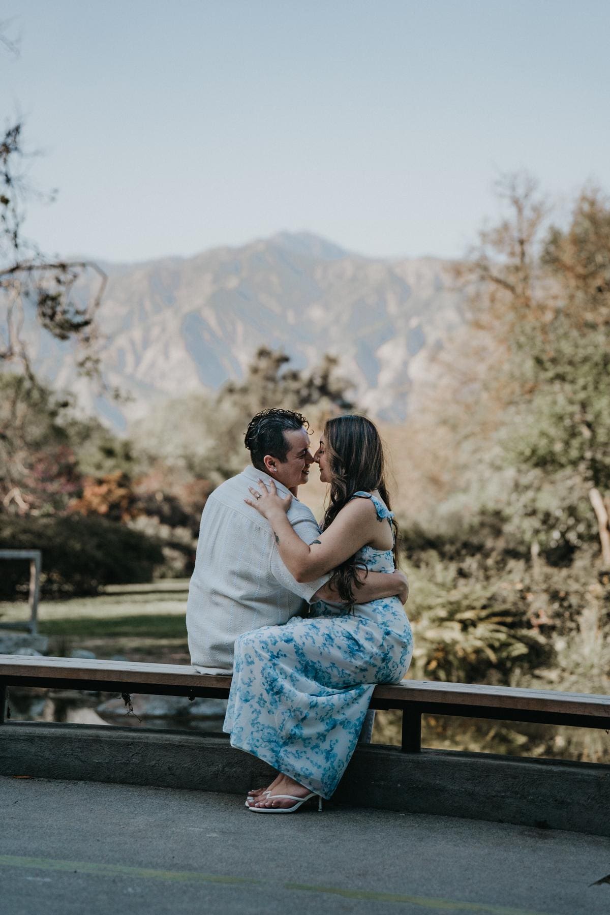 Couple kissing with the San Gabriel Mountains rising behind them.