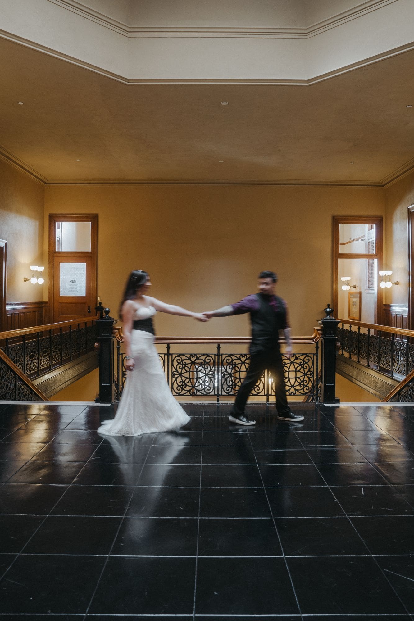 A softly blurred portrait of the couple walking together along the upstairs railing.