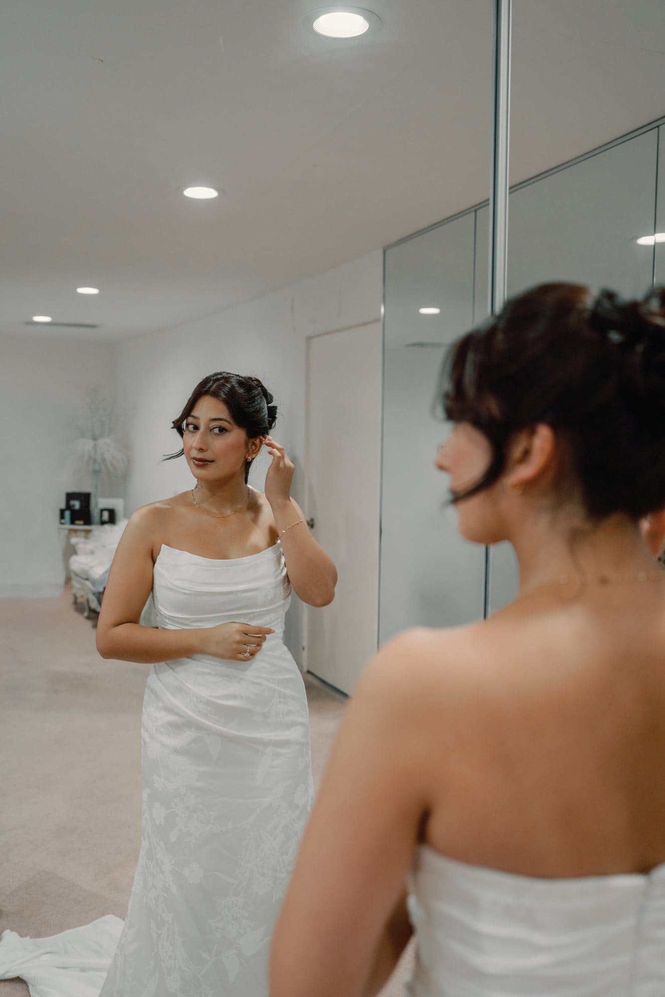 The bride looks at her reflection in a bridal-suite mirror at The Santa Anita Church in Arcadia, California.