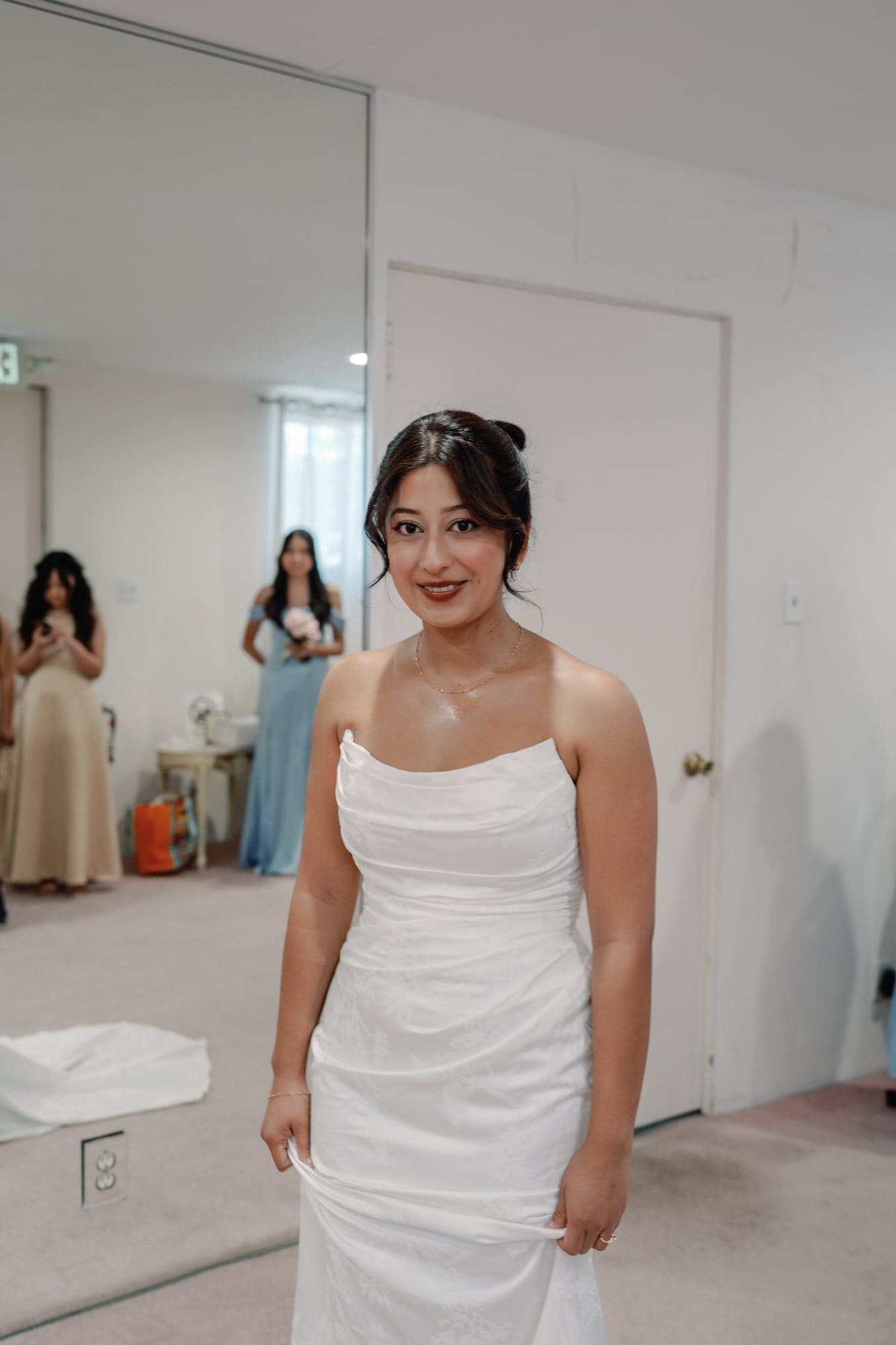 The bride stands in her wedding dress in the bridal suite at The Santa Anita Church in Arcadia, California.