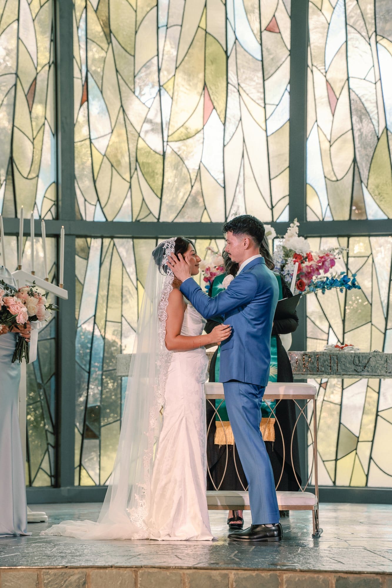 The couple kisses in front of the stained glass during the ceremony at The Santa Anita Church in Arcadia, California.