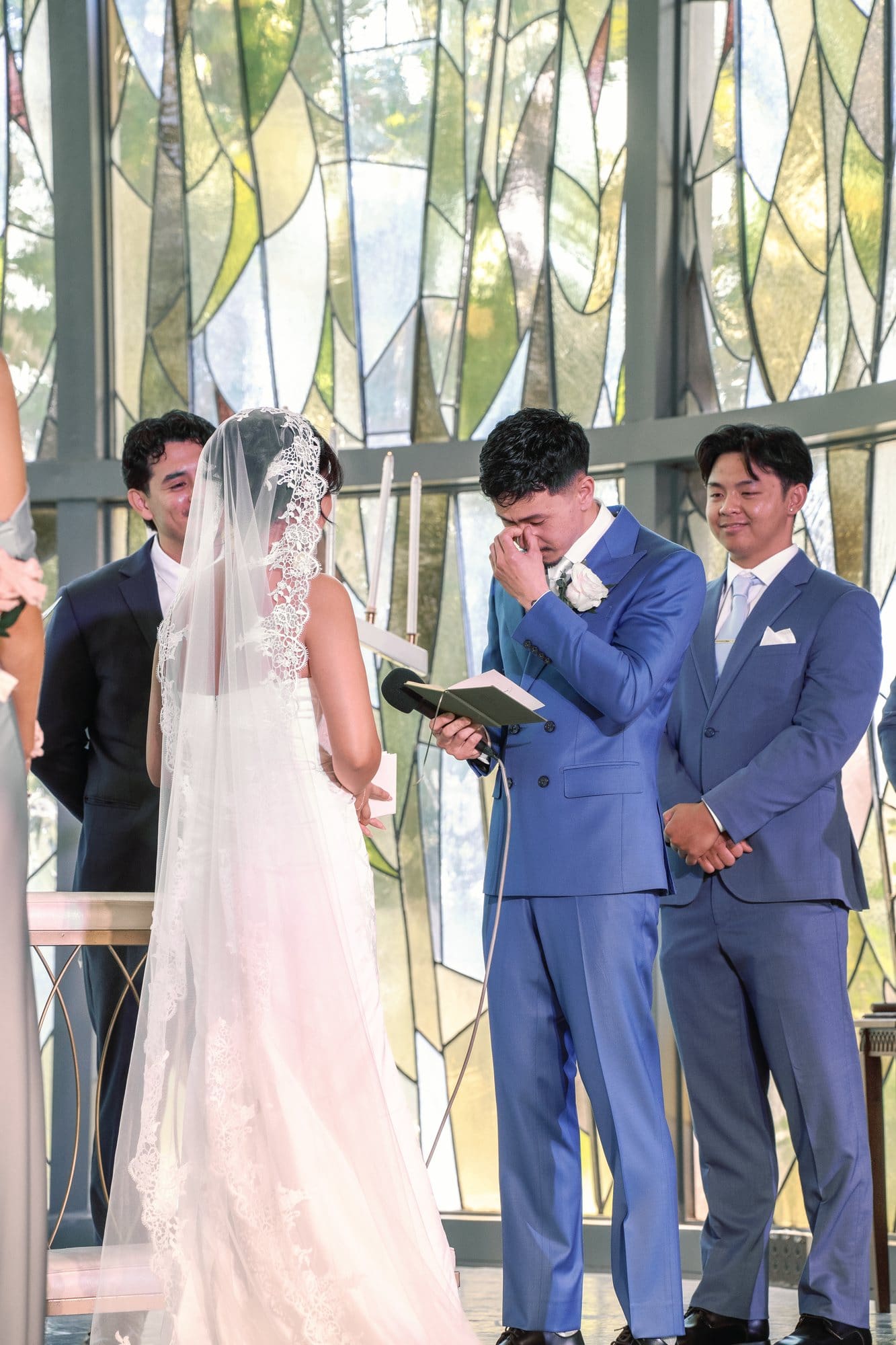 The groom holds a booklet while facing the bride during the ceremony at The Santa Anita Church in Arcadia, California.