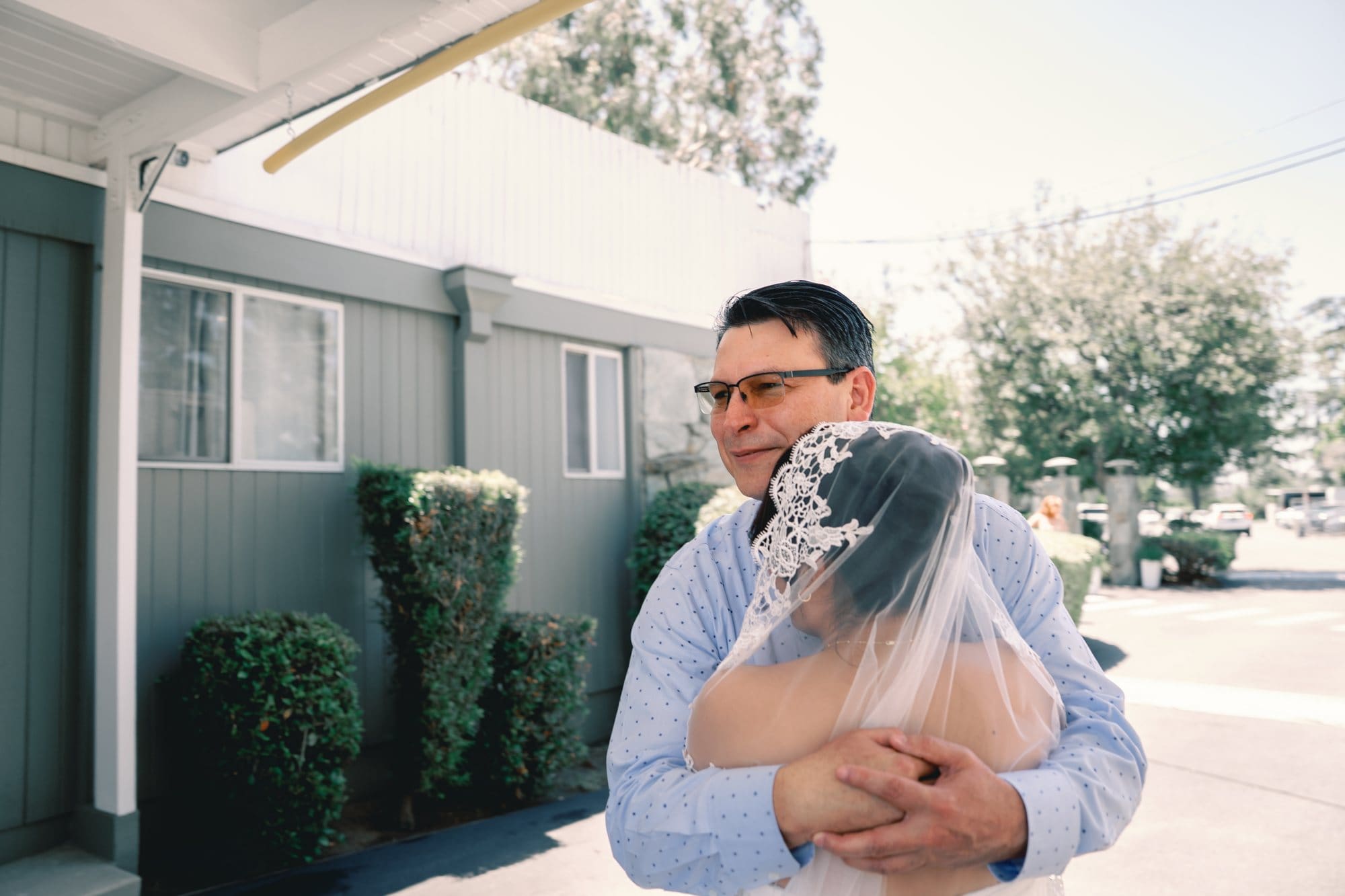 The bride embraces her dad outside the bridal suite at The Santa Anita Church in Arcadia, California.