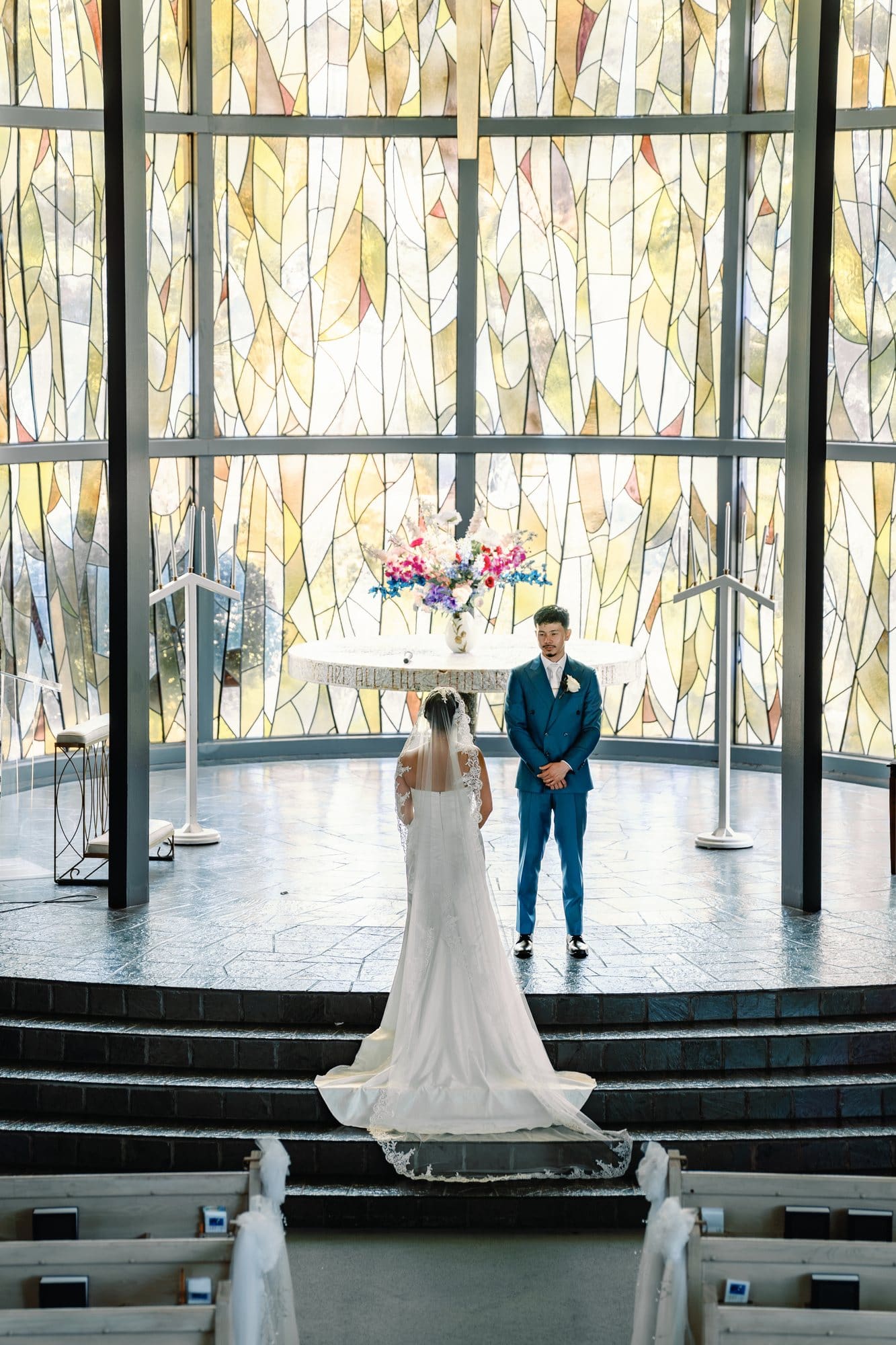 Viewed from above, the couple holds hands beneath the stained glass at The Santa Anita Church in Arcadia, California.